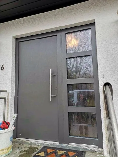 Graue Haustür mit seitlichen Glaselementen