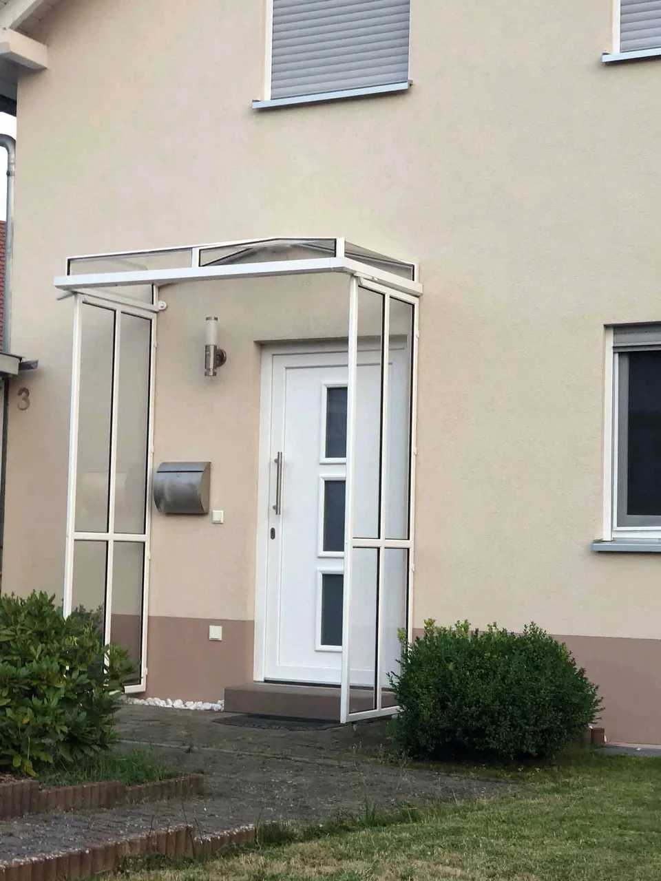 Weiße Haustür mit geschütztem Eingangsbereich