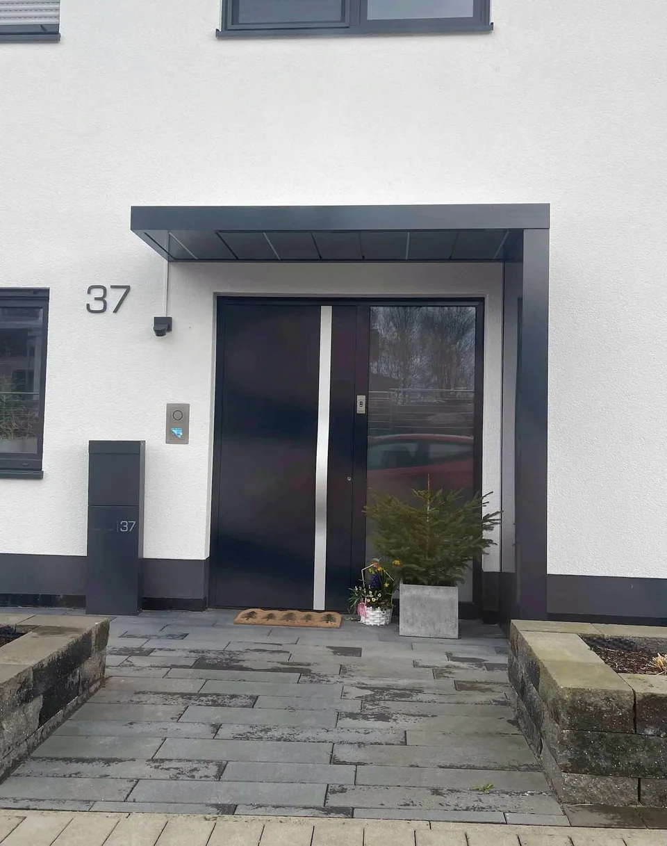 Dunkle Haustür mit modernem Vordach
